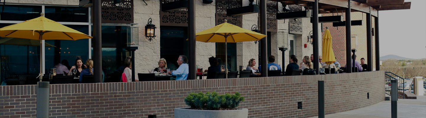 Guests dining outside on outdoor patio under yellow umbrellas
