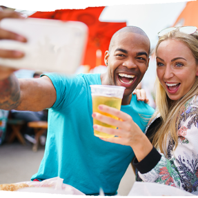 two people taking a selfie holding a drink