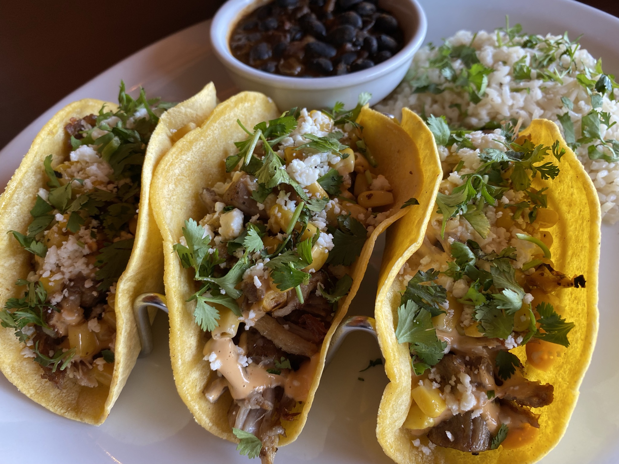 Carnitas Tacos with small bowl of beans and side of rice