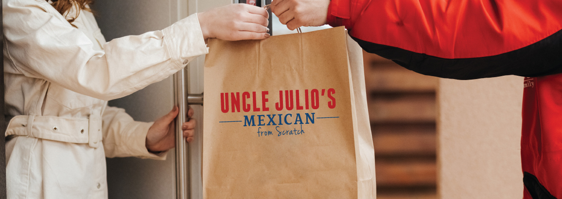 Uncle Julio's to go order being handed off to customer