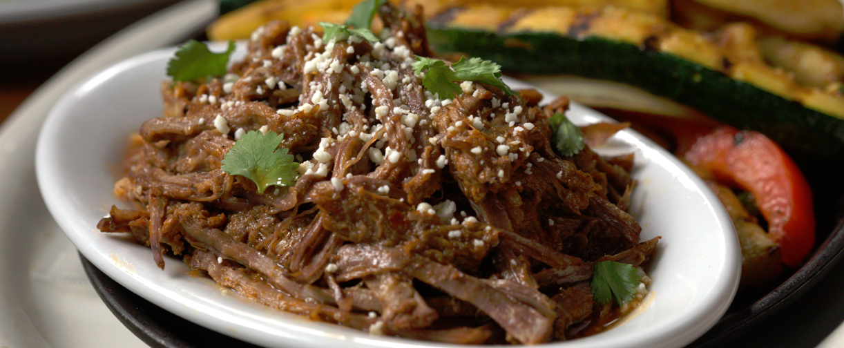 barbacoa beef on a plate with vegetables