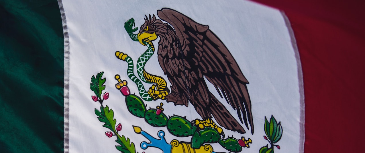 Image of Mexican flag. Green, white and red flag with an eagle holding a snake.