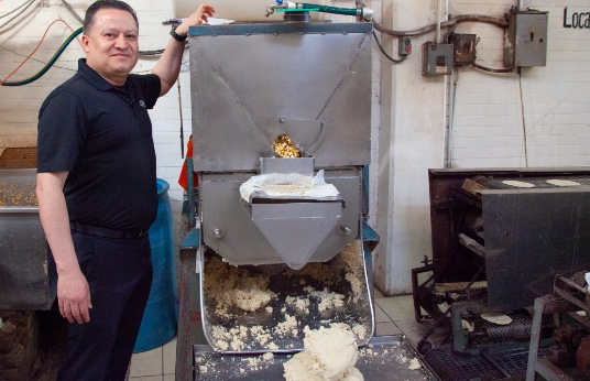 Chef Ron Vasquez standing next to tortilla machine