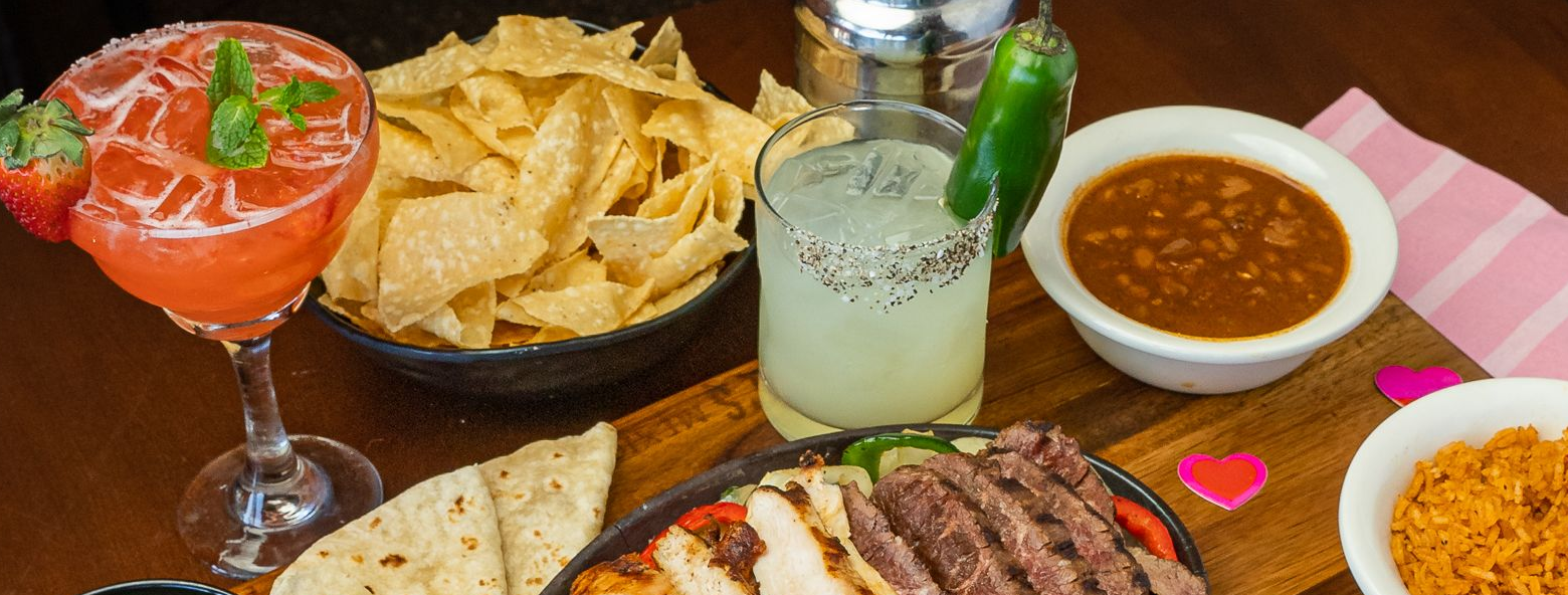chicken and steak fajitas served with sides and margaritas